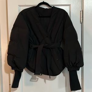 Black quilted short asymmetrical puffer jacket with ribbed cuffs and belt